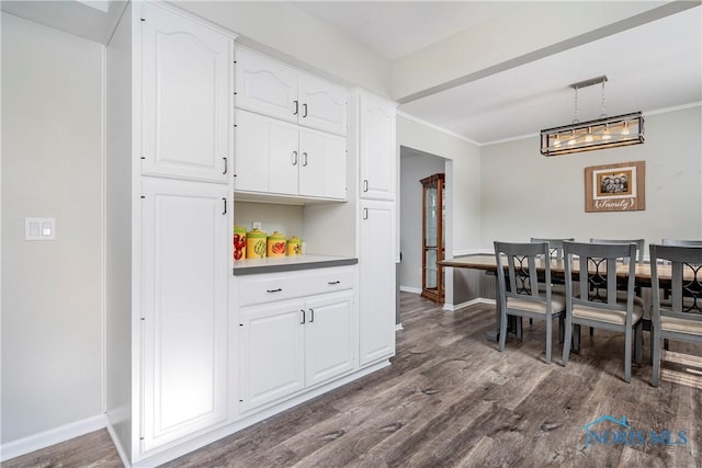 dining room with ornamental molding, dark wood finished floors, and baseboards