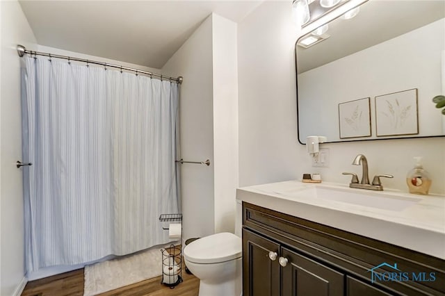 full bath featuring vanity, wood finished floors, and toilet