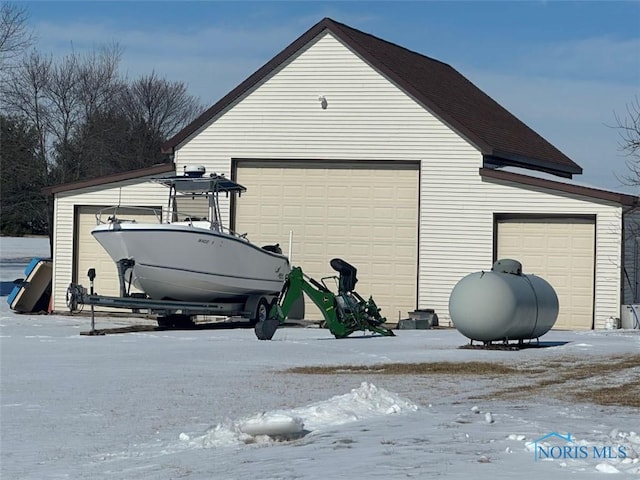 snow covered garage with a garage