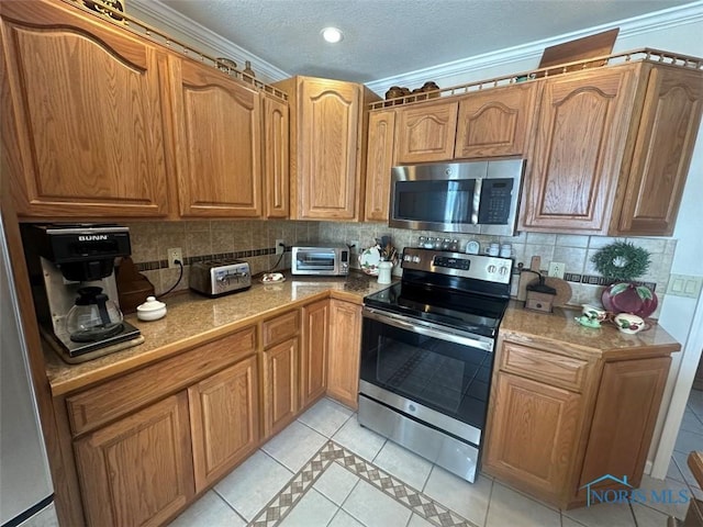 kitchen featuring brown cabinets, light tile patterned floors, stainless steel appliances, and backsplash