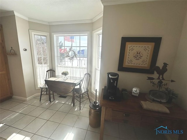 dining space with light tile patterned floors, baseboards, and crown molding