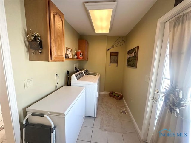 washroom with washer and clothes dryer, visible vents, cabinet space, light tile patterned flooring, and baseboards