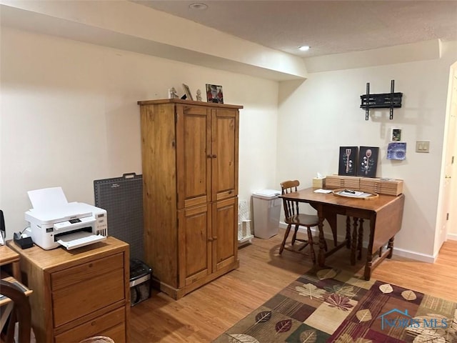 office space featuring light wood-type flooring and baseboards