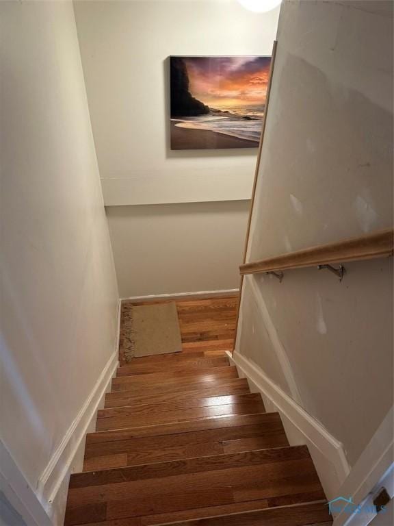 stairs featuring wood finished floors and baseboards