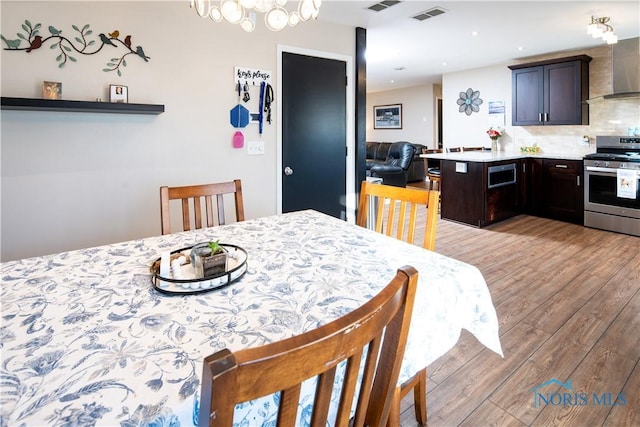 dining room featuring light wood finished floors, visible vents, and recessed lighting