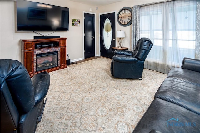 living room featuring a fireplace and baseboards