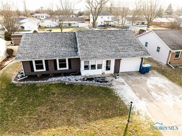 view of front facade with a shingled roof, a residential view, a front lawn, and concrete driveway