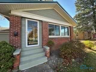 view of side of property featuring entry steps and brick siding