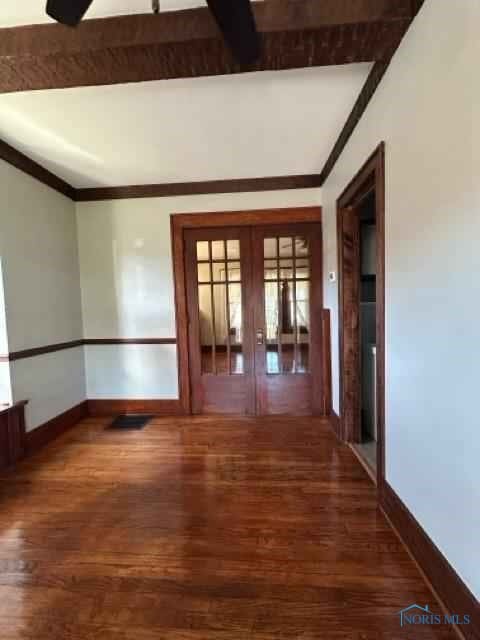 spare room featuring ornamental molding, french doors, dark wood-style flooring, and baseboards