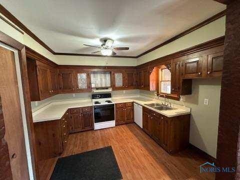 kitchen featuring white appliances, light countertops, a sink, and light wood-style flooring