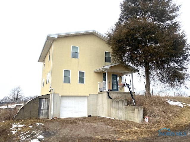 view of front facade with driveway, an attached garage, and stucco siding