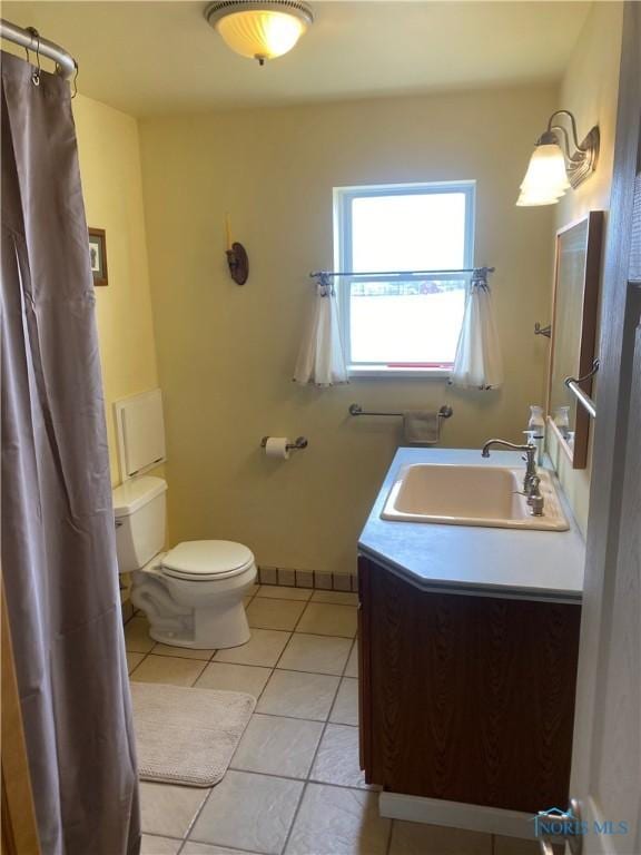 bathroom featuring toilet, tile patterned flooring, vanity, and baseboards