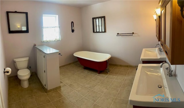 full bath featuring tile patterned flooring, a soaking tub, a sink, and toilet