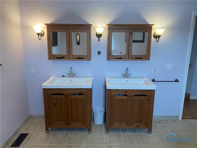 bathroom featuring two vanities, visible vents, a sink, and baseboards