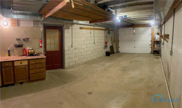 garage featuring a workshop area and concrete block wall