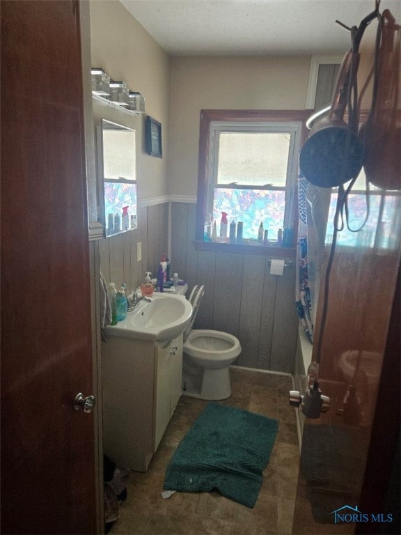 full bathroom featuring tile patterned flooring, toilet, a wainscoted wall, vanity, and shower / tub combo with curtain