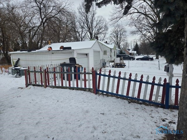 exterior space with a detached garage, fence, and an outdoor structure