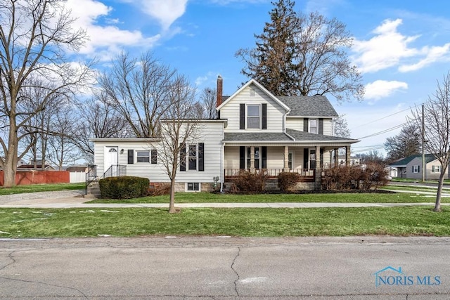 view of front facade with a chimney, a shingled roof, covered porch, a front yard, and fence