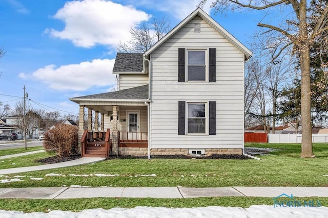 view of front of home featuring covered porch, roof with shingles, fence, and a front lawn