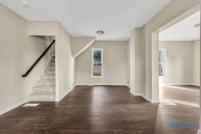 interior space with dark wood-style floors, stairs, visible vents, and baseboards