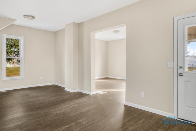 unfurnished room featuring dark wood-style floors and baseboards