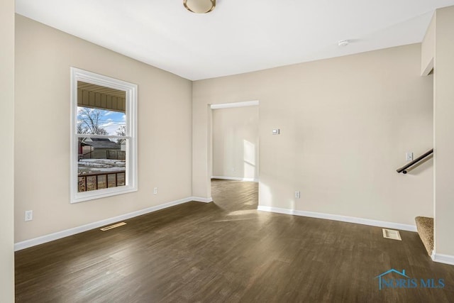 unfurnished living room featuring stairs, dark wood finished floors, visible vents, and baseboards