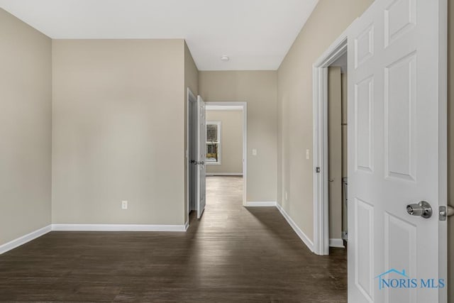 hall with baseboards and dark wood finished floors