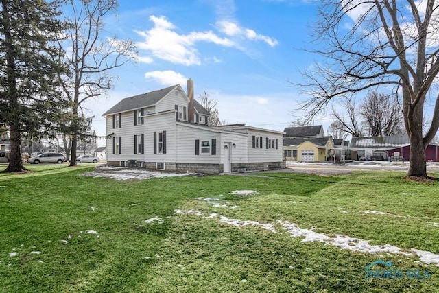 rear view of house featuring a residential view, a yard, and a chimney