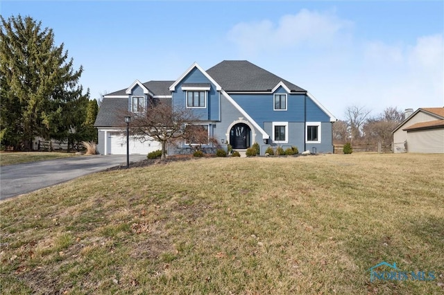 view of front of home featuring aphalt driveway, a front yard, an attached garage, and fence