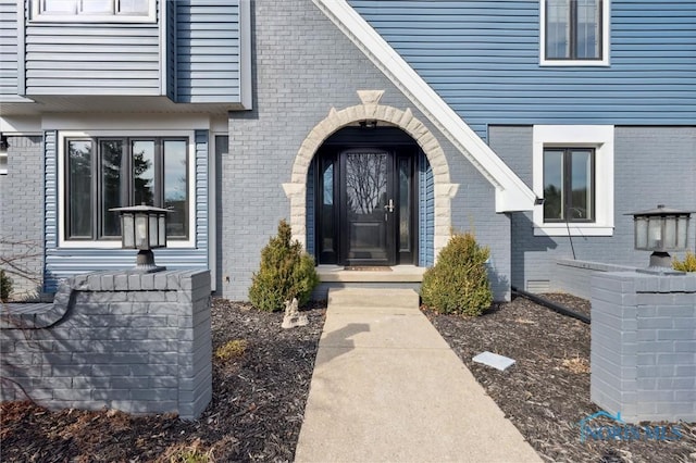 view of exterior entry with brick siding