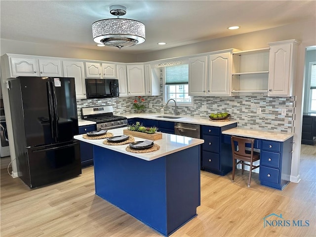 kitchen with a center island, light countertops, white cabinets, blue cabinets, and black appliances