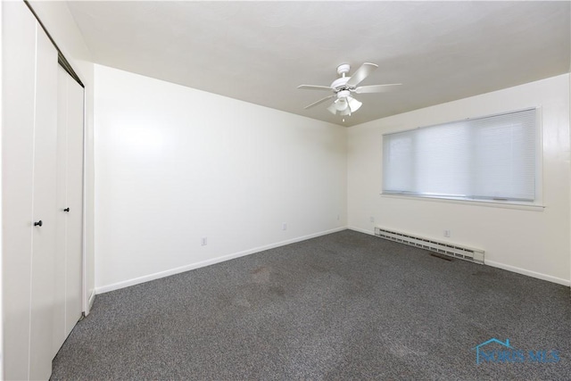 spare room featuring a ceiling fan, a baseboard radiator, dark carpet, and baseboards