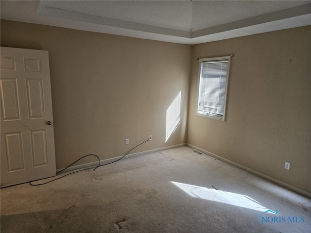 empty room featuring light carpet, visible vents, and baseboards