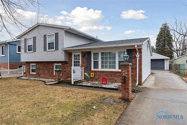 split level home with an outbuilding, brick siding, fence, a garage, and a front lawn