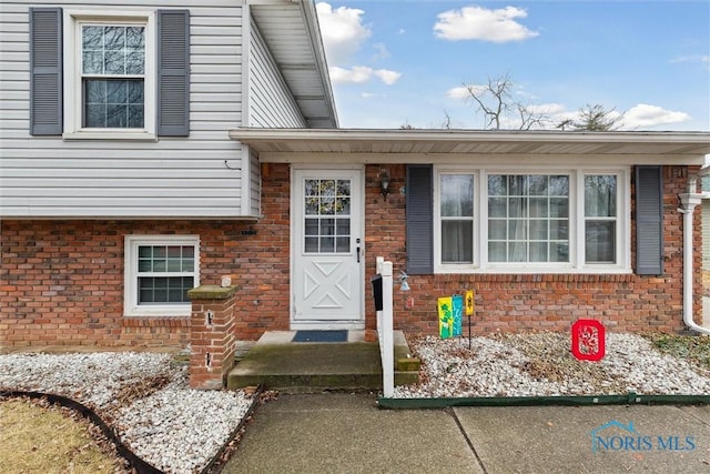 view of exterior entry with brick siding