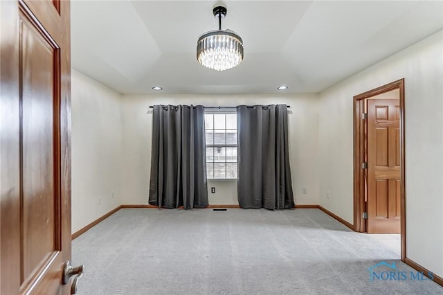 empty room featuring recessed lighting, light carpet, baseboards, and an inviting chandelier