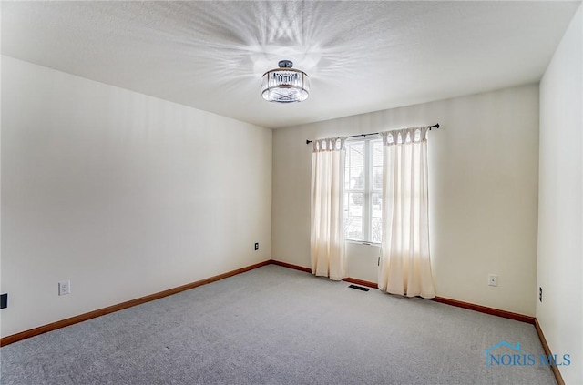 empty room with light colored carpet, visible vents, and baseboards