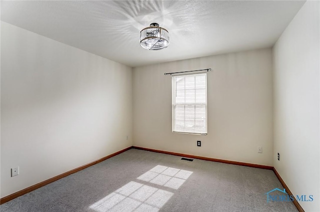 empty room featuring light carpet, baseboards, and visible vents