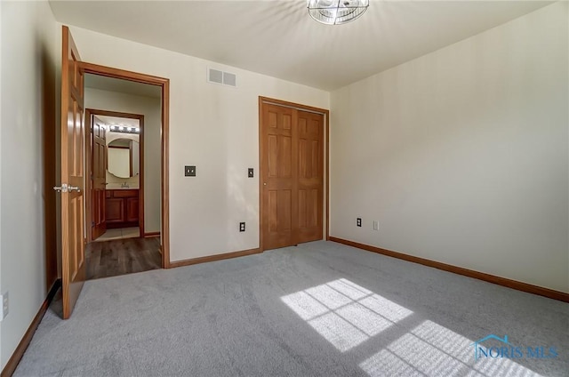 unfurnished bedroom with baseboards, a closet, visible vents, and carpet flooring