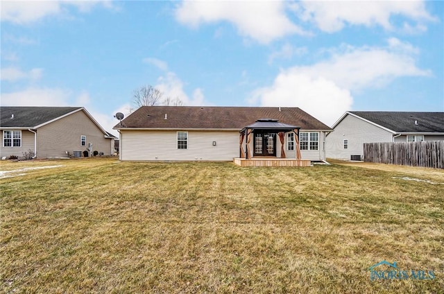 rear view of property featuring a gazebo, a lawn, cooling unit, and fence