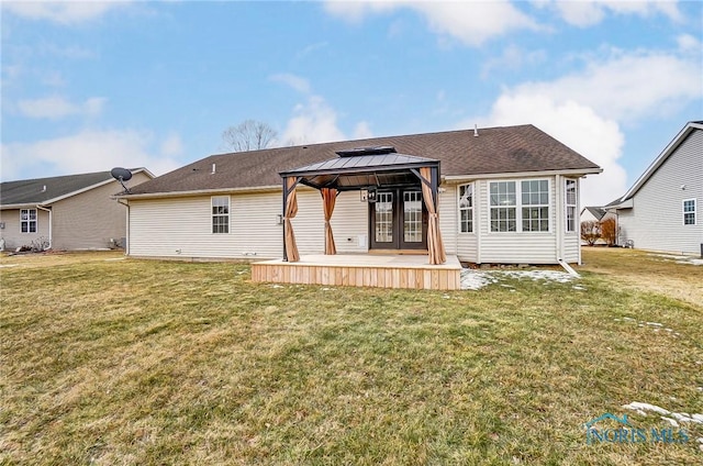 rear view of house with a wooden deck, a lawn, and a gazebo