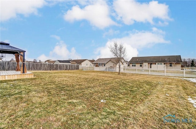 view of yard with a gazebo, a fenced backyard, and a residential view