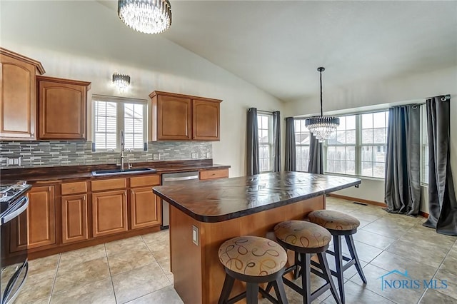 kitchen featuring a chandelier, appliances with stainless steel finishes, dark countertops, and a kitchen island