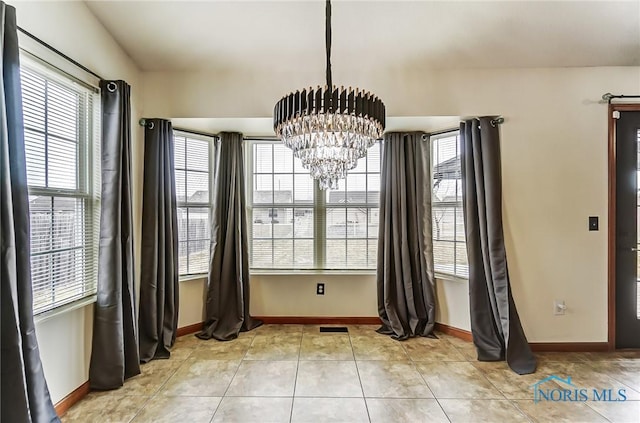 unfurnished dining area with a chandelier, light tile patterned flooring, visible vents, and baseboards