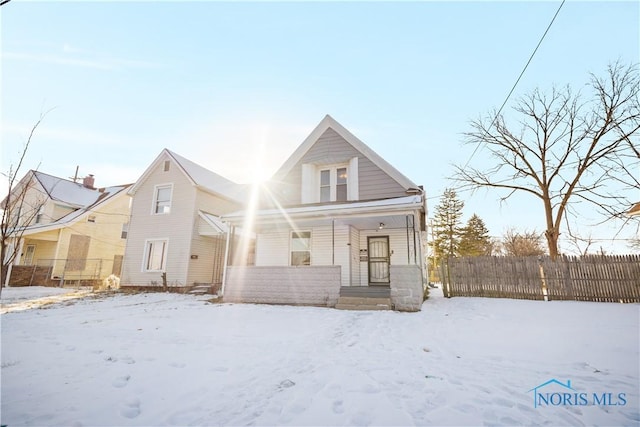 view of front of home featuring covered porch and fence