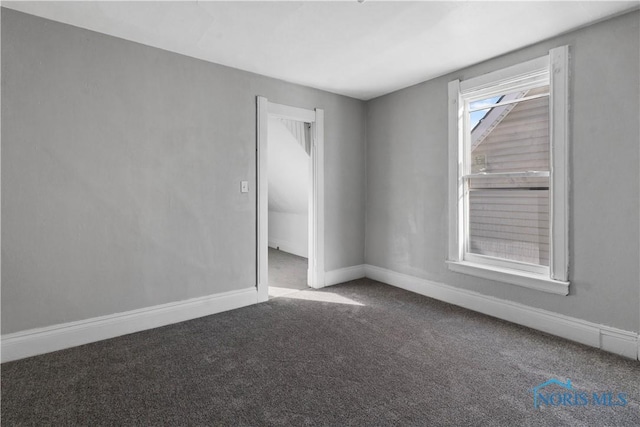 unfurnished room featuring carpet floors and baseboards