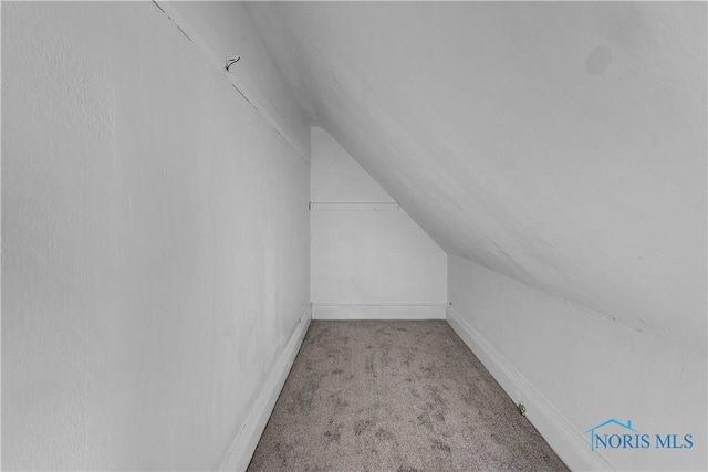 bonus room featuring light colored carpet, vaulted ceiling, and baseboards