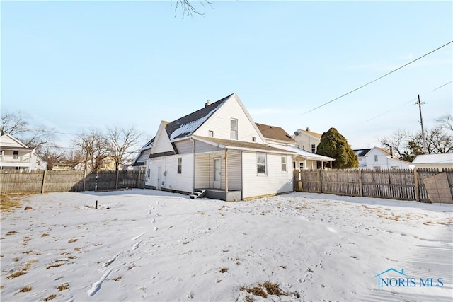 snow covered back of property with fence private yard