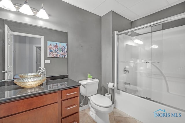 full bath featuring tile patterned flooring, vanity, toilet, and bath / shower combo with glass door