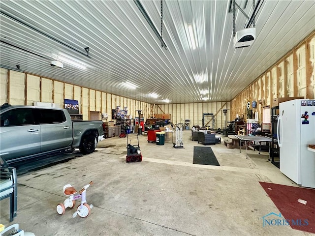 3190 Rd 204, Antwerp, OH 45813 - garage with freestanding refrigerator, a workshop area, and a garage door opener